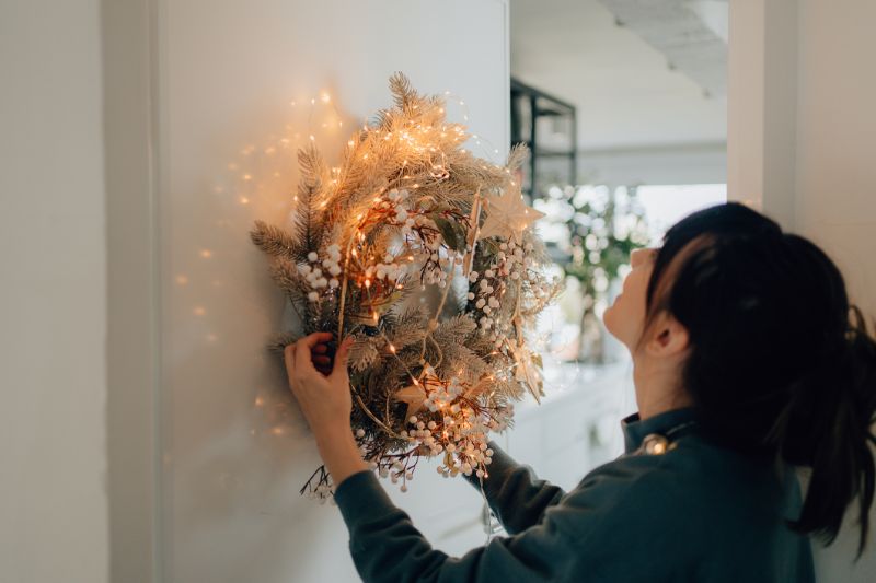 young woman decorating her living room for the upcoming holidays